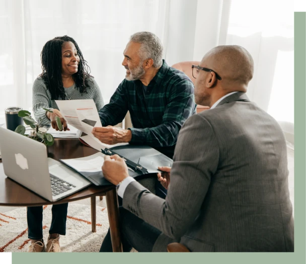 Business meeting with three people discussing documents.